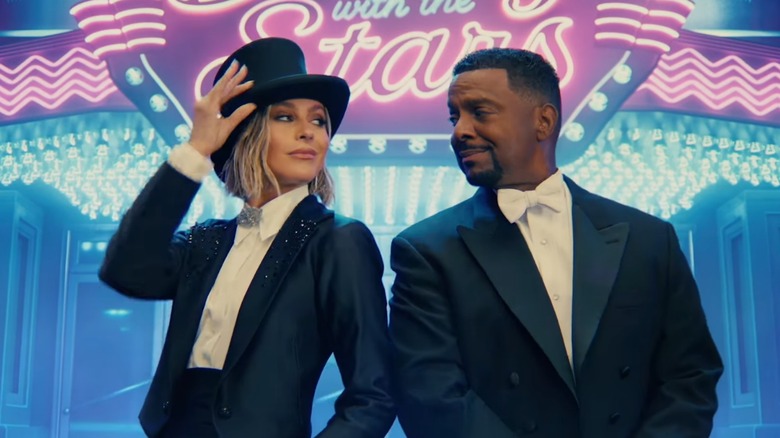 Dancing with the Stars hosts Julianne Hough and Alfonso Ribeiro in front of the show's name in lights behind them