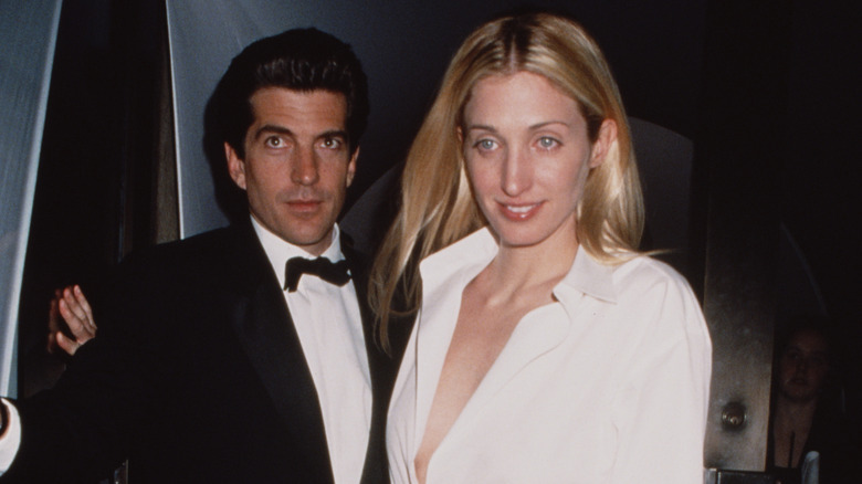 John F. Kennedy Jr. and Carolyn Bessette-Kennedy smiling in formal attire