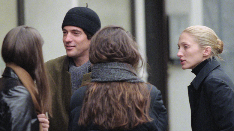 JFK Jr., Carolyn Bessette Kennedy, and Lauren Bessette talking outside on street in New York City
