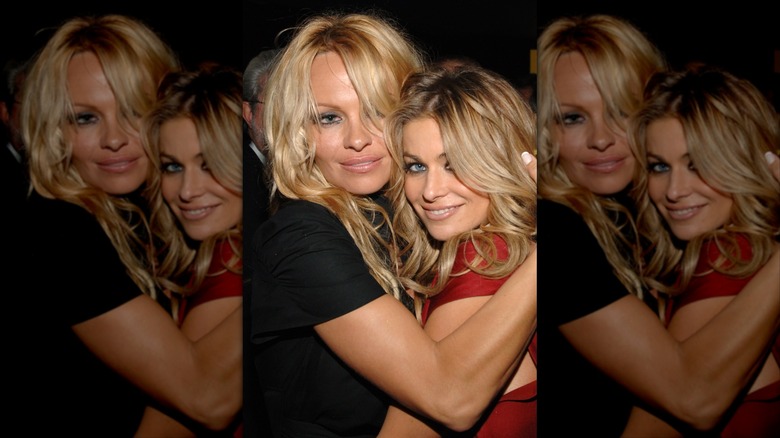 Pamela Anderson and Carmen Electra hugging during a 2000s club appearance.