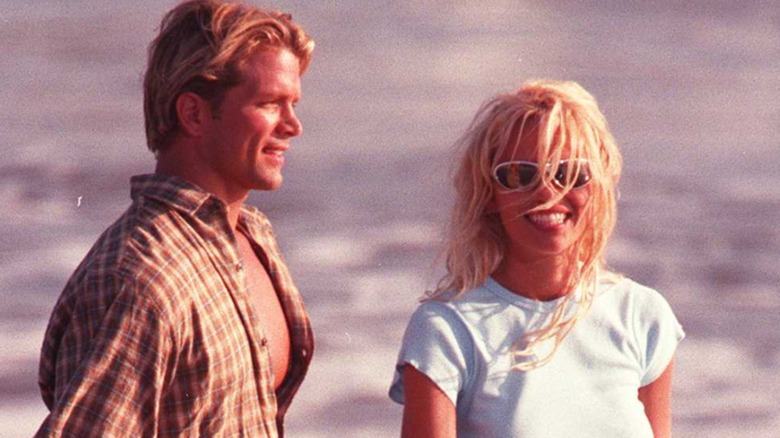David Chokachi and Pamela Anderson smiling on the beach while filming an episode of Baywatch.