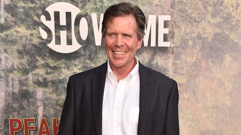 Grant Goodeve smiling and wearing a suit jacket