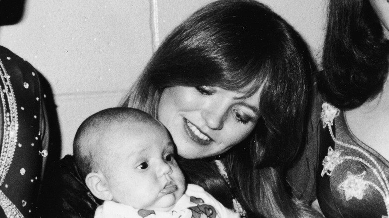 Susan Richardson holding a baby and smiling