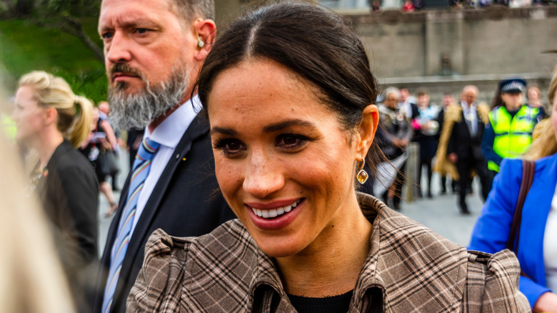 Meghan Markle smiling, greeting fans