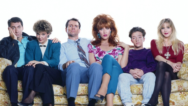Cast of Married... With Children sitting on a couch in 1989.
