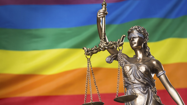 statue in front of LGBTQ flag