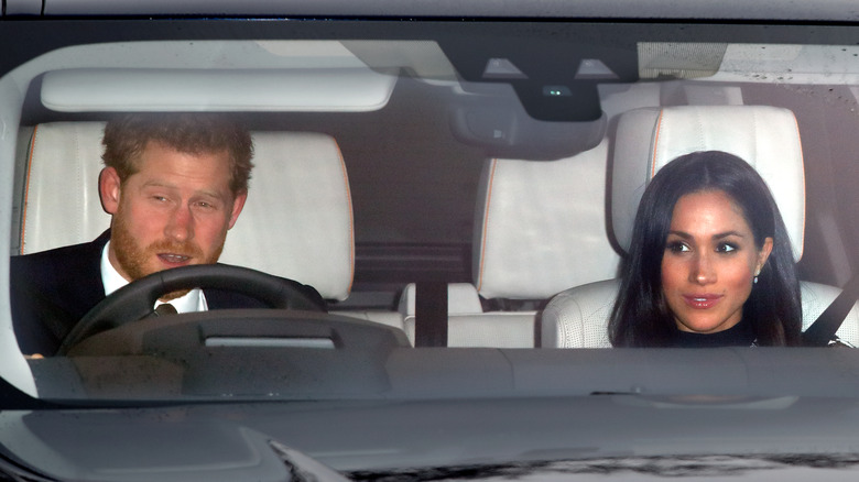 Prince Harry driving with Meghan Markle in the passenger seat