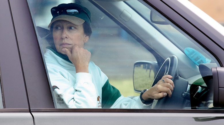 Princess Anne looking over her shoulder from the driver's seat