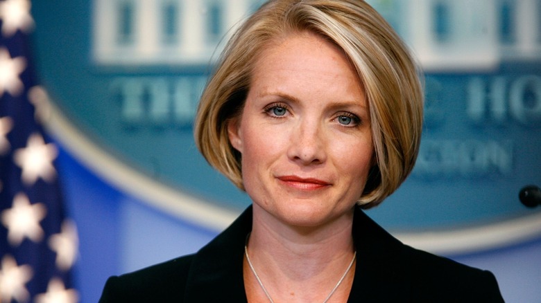 Dana Perino smirking in front of the seal in the briefing room