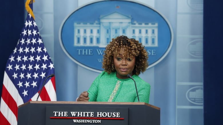 Karine Jean-Pierre standing at the podium in the White House briefing room