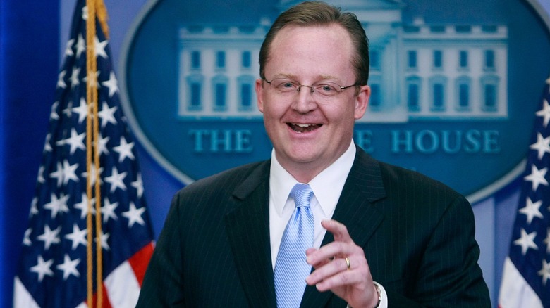 Robert Gibbs smiling at the podium in the briefing room