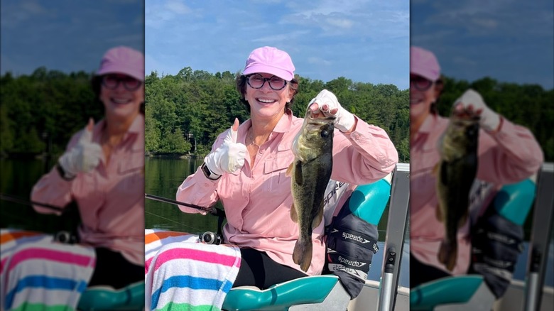 Kathy Levine holds a fish in a selfie on a boat