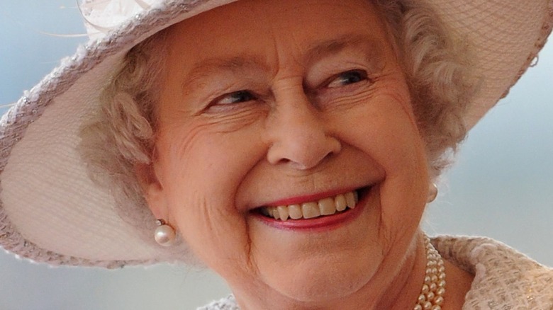 Queen Elizabeth II smiling in white