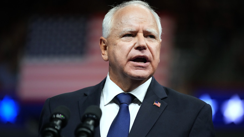 Tim Walz delivering a speech in a black suit