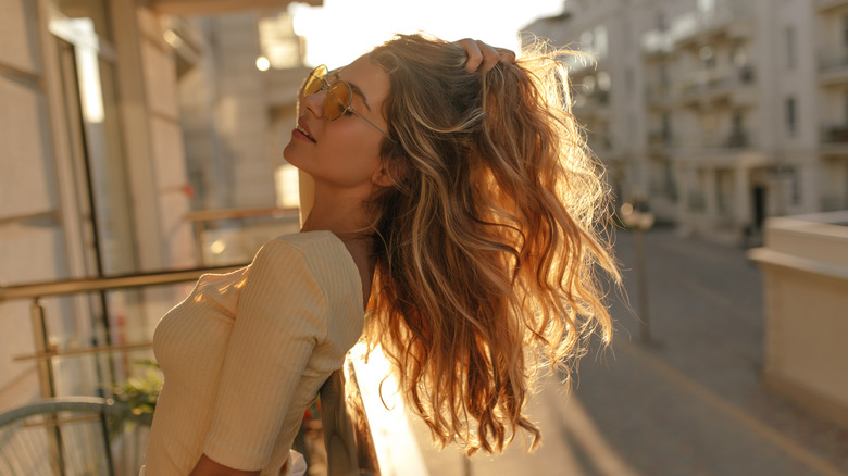 woman showing off hair on a balcony