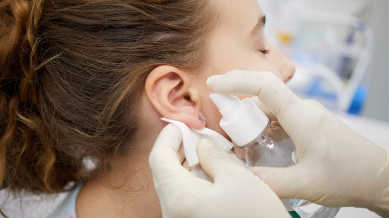 spraying saline on ear piercing