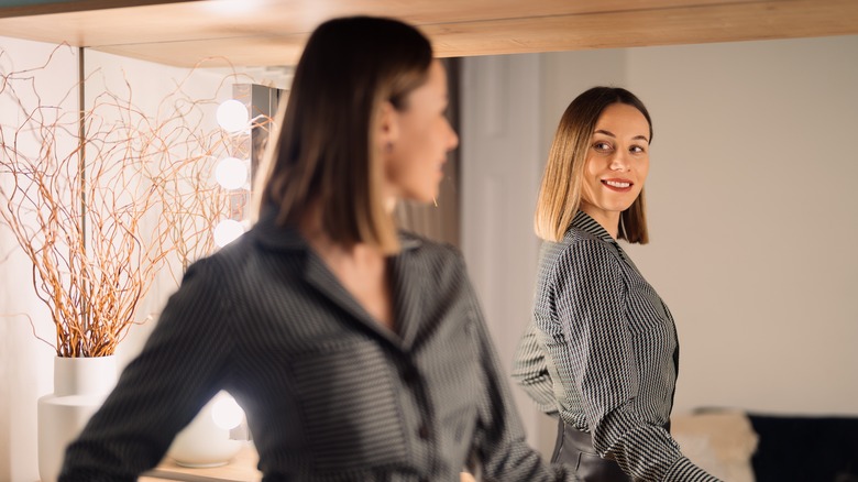Confident woman looking in mirror