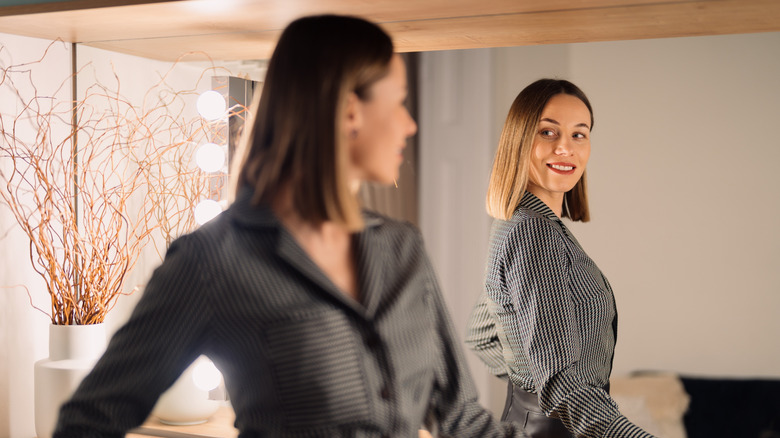 Confident woman looking in mirror