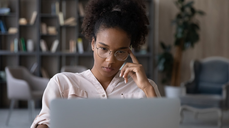 A woman looking burnt out in front of her computer. 