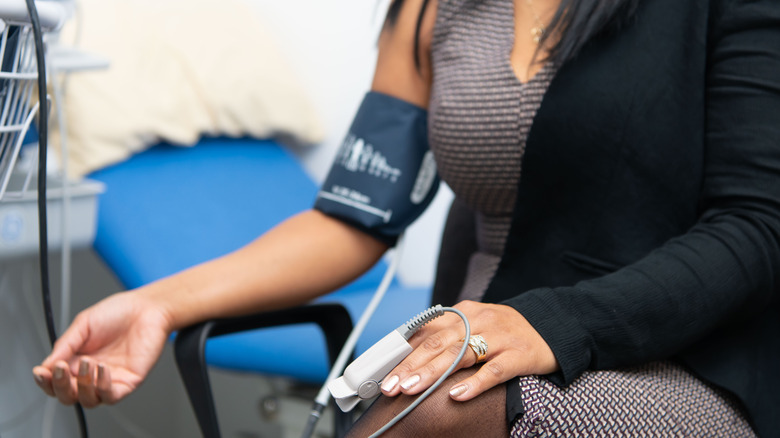 Woman having blood pressure checked