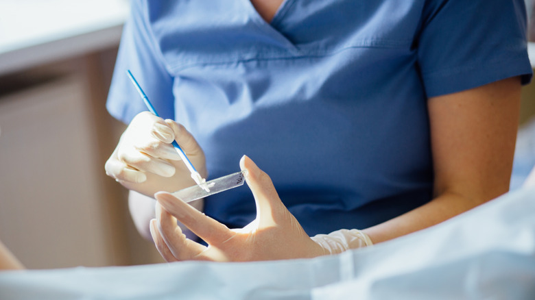 Doctor collecting cervical cells during a pap test