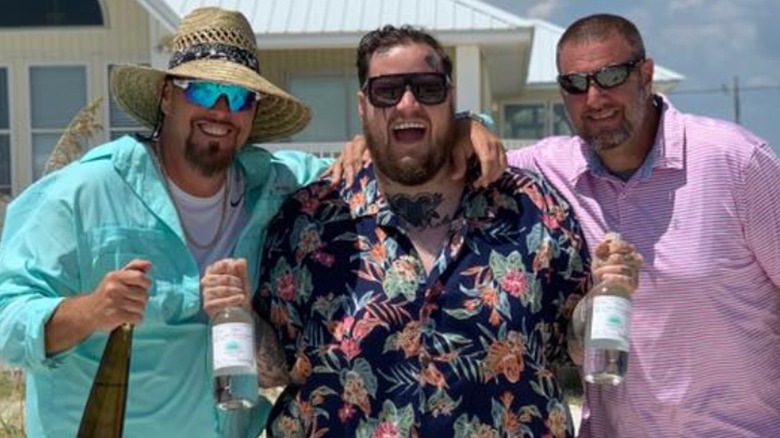 Jelly Roll posing with his brothers and tequila bottles