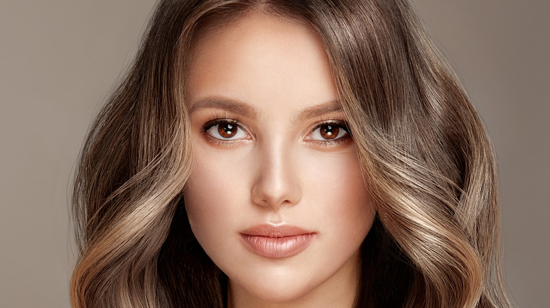 Woman with wavy shiny balayage hair 