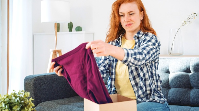 Woman displeased when opening a box with pants