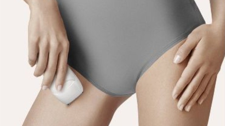 woman using epilator bikini line