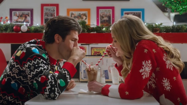 Franco Lo Presti and Ashley Newbrough sharing a milkshake in festive holiday garb