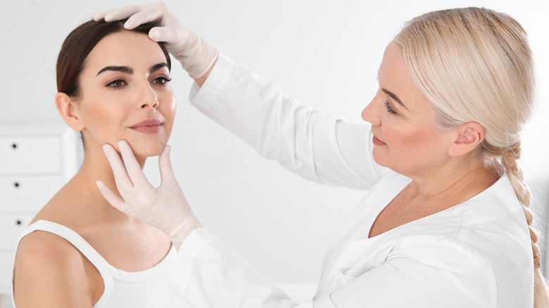 Dermatologist examining woman's mole