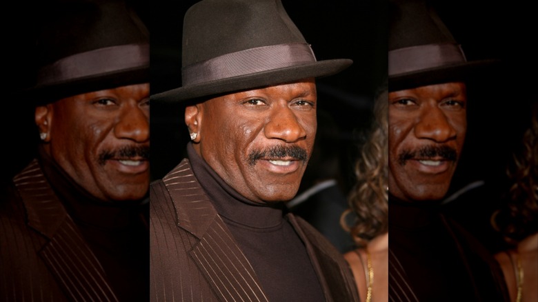 Ving Rhames wearing a brown fedora and matching suit.