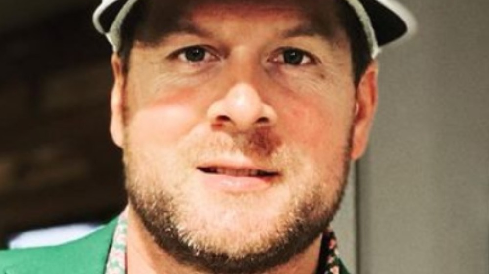 Dale Mills wears a green jacket in and white visor in an Instagram photo.