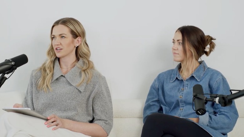 Kassidy Peters and Kennedy Frick sitting on a couch in front of podcast microphones