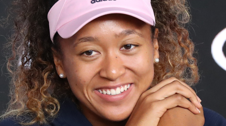 Naomi Osaka smiling, pink visor