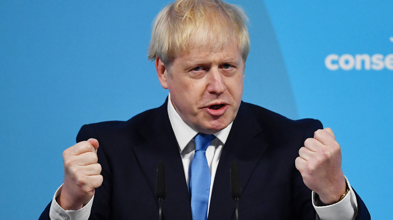 Boris Johnson holds up his fists onstage