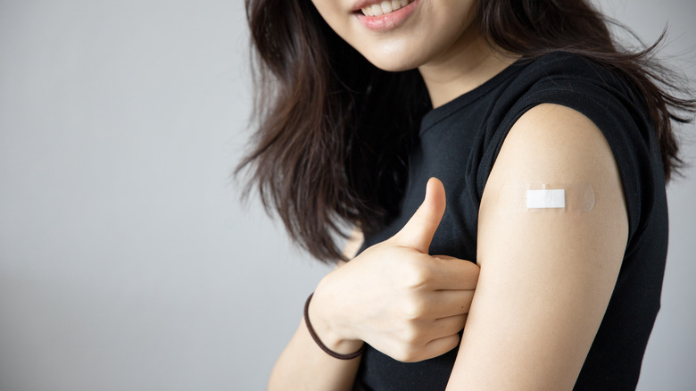 woman gives thumbs up after getting vaccinated