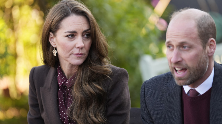 Princess Catherine looking at Prince William while he speaks to someone