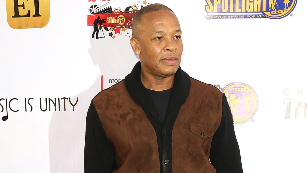 Dr. Dre posing in brown cardigan