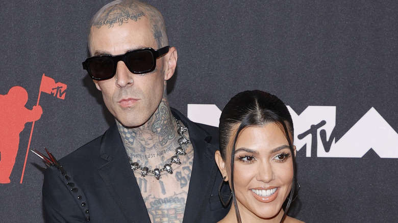 Kourtney Kardashian and Travis Barker attending an event