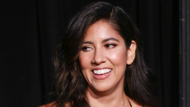 Stephanie Beatriz looking sideways and laughing nervously