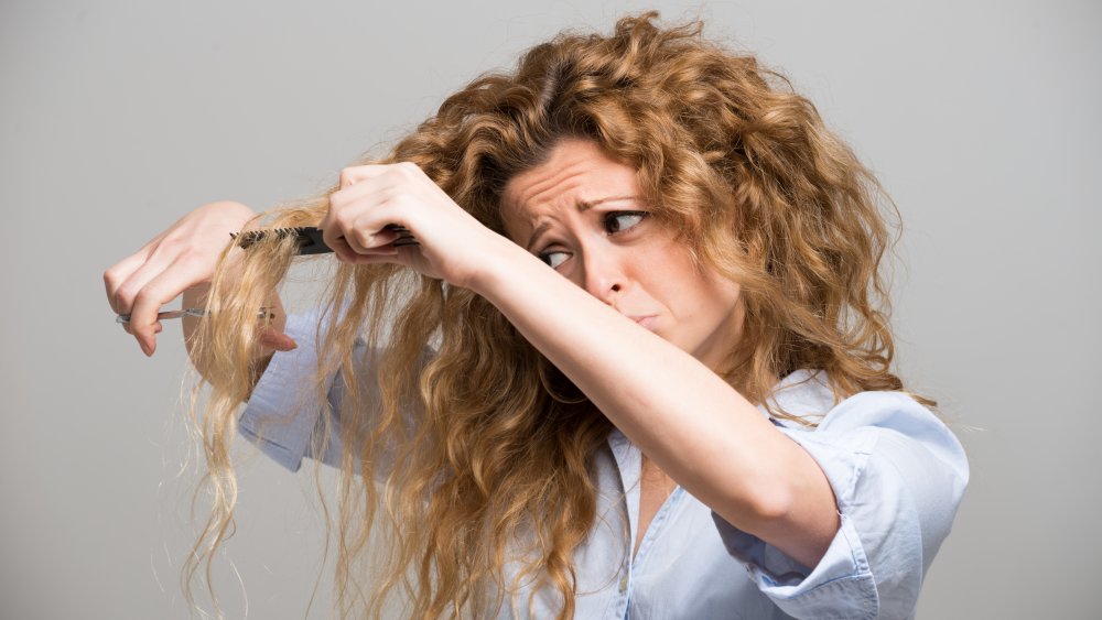 Woman cutting her long hair