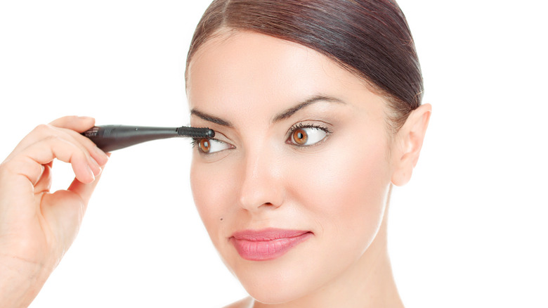 Woman using heated eyelash curler