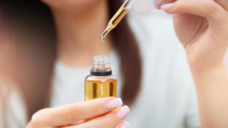 Woman using oil dropper