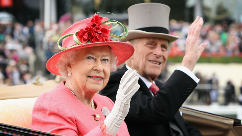 Queen Elizabeth and Prince Philip waving to onlookers