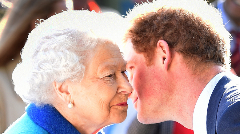 Prince Harry leans over to kiss the queen