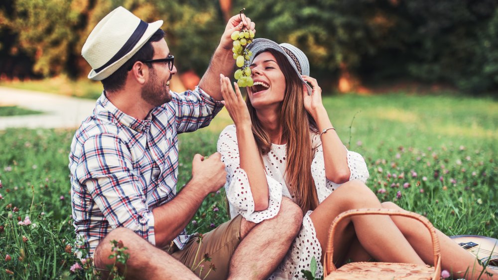 Couple happily eating grapes