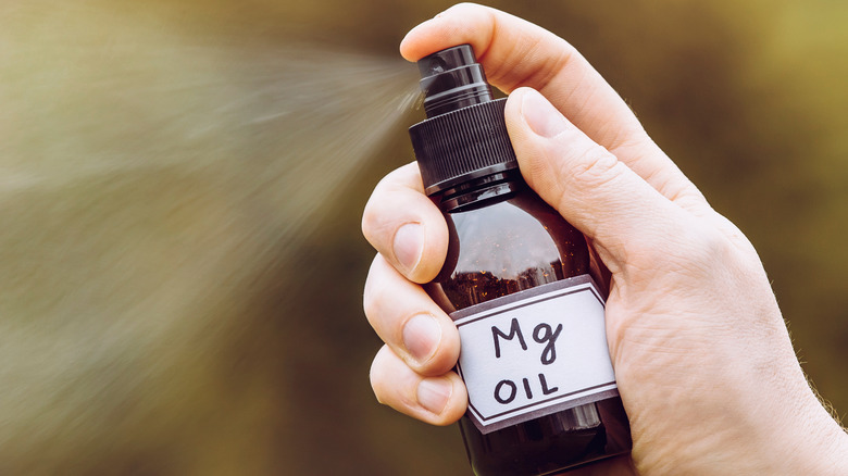 Woman spraying magnesium oil on her skin