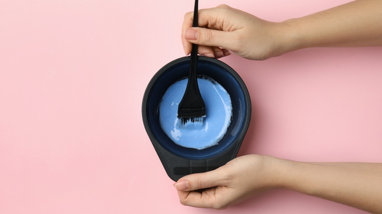 Blue hair dye mix in bowl with applicator