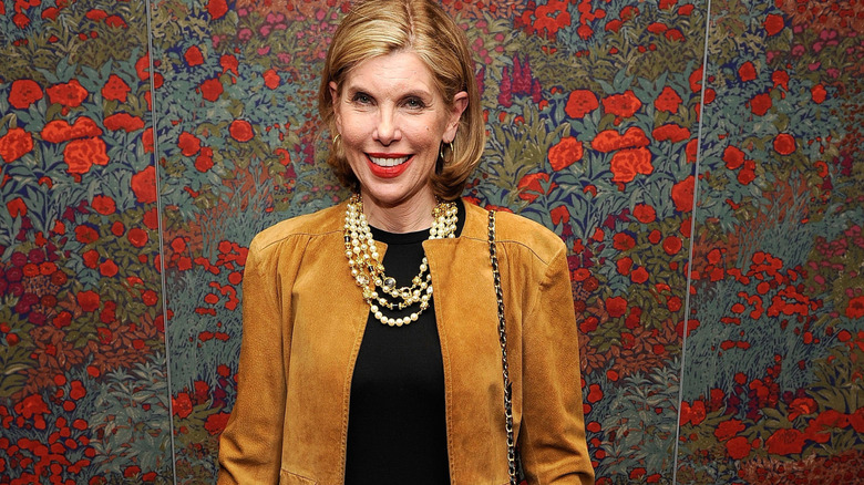 Christine Baranski smiling by flowered wall
